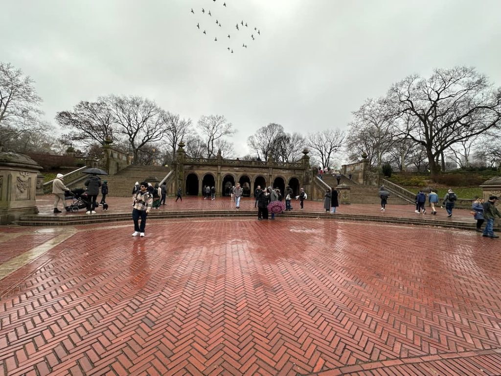 Photo de la place en pavé rouge de Central Park avec des arbres autour, à New York en hiver