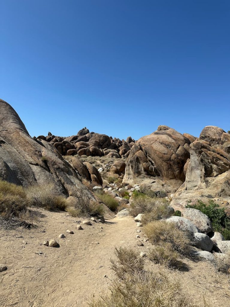 Photo d'un chemin de sable bordé de petits cailloux t aux Alabama Hills près de Lone Pine, Californie