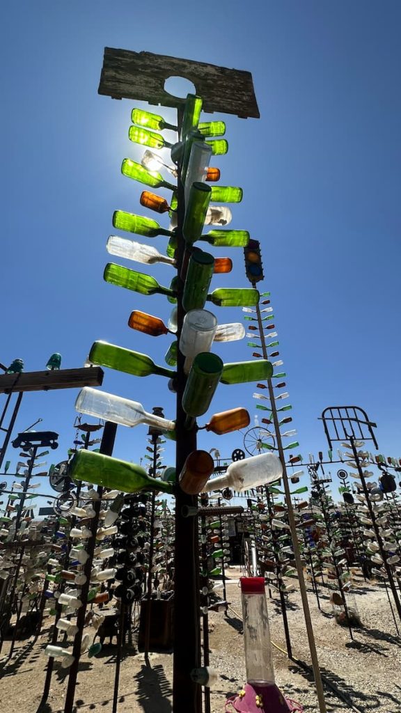 Une composition de bouteilles en verre et de fer représentant un arbre à Elmer's Bottle Tree Ranch sur la route 66