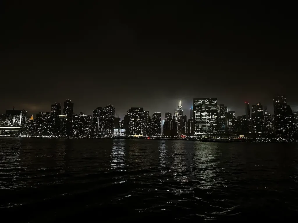 Photo de la skyline illuminée de nuit, à Gantry Plaza State Park, New York