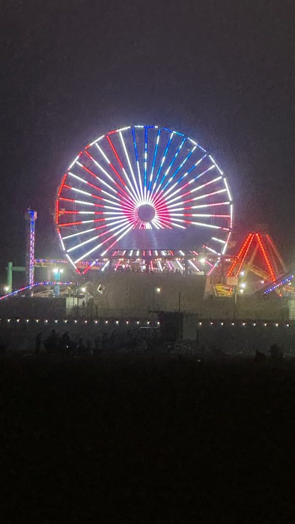 Grande roue de Pacific Park à Santa Monica prise en photo de nuit, illuminée aux couleurs du drapeau américain, à Los Angeles, Californie