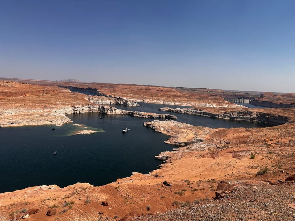 Photo du Lake Powell avec des bateaux en mouvement à Page Arizona avec le Glem barrage en fond