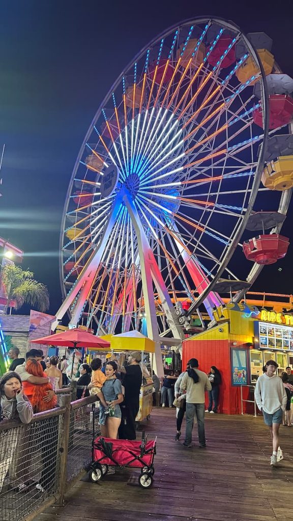 Photo de la grande roue de Pacific Park, de nuit, avec la foule et les enfants, Santa Monica à Los Angeles, Californie