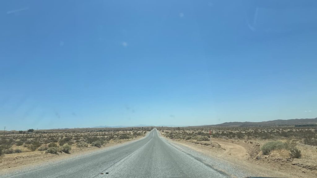 Route goudronnée s'étendant à perte de vue sur la route 66 avec le désert de part et d'autre