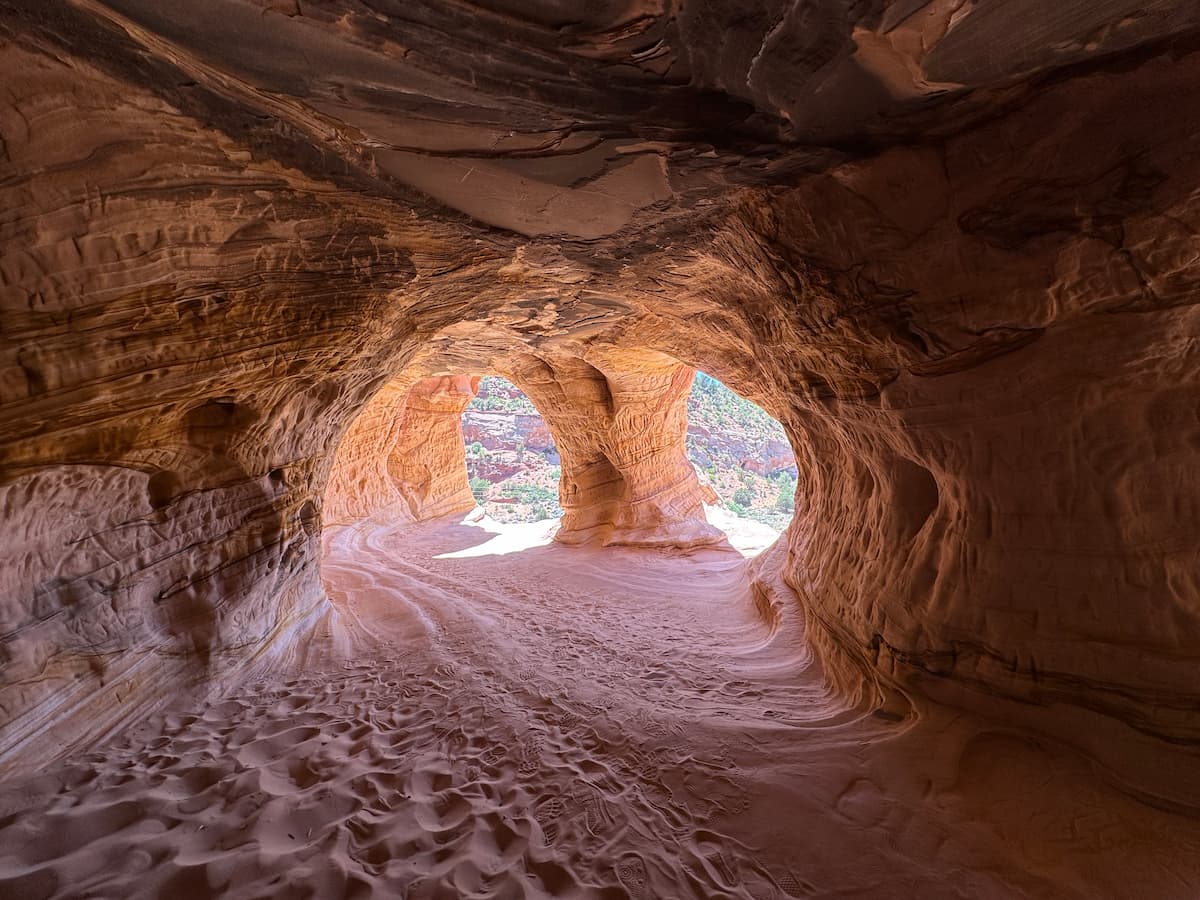 Photo de l'intérieur des Sand Caves, avec la vue sur la végétation à travers les ouvertures, près de Kanab