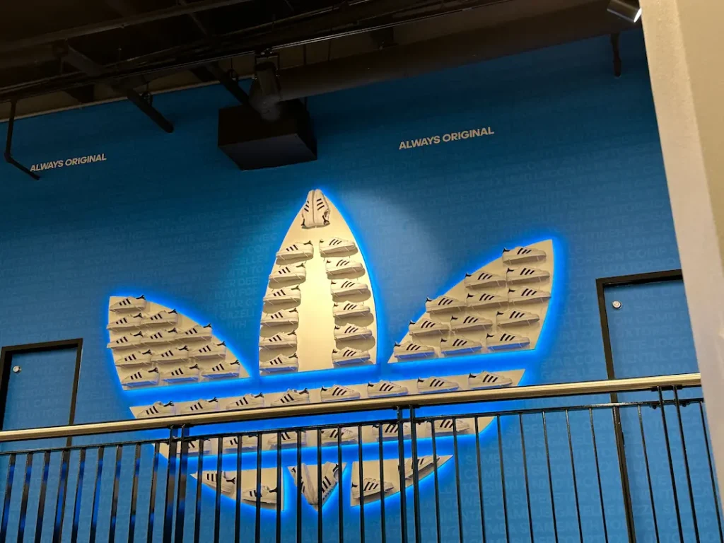 Mur intérieur du magasin Adidas à New York, la fleur emblème de la marque est réalisée en basket superstar.