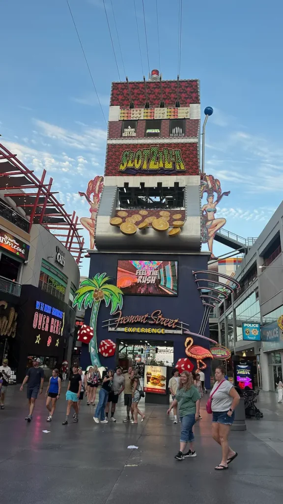 Vue de l'entrée de Fremont Street, avec la machine à sous géante SlotZilla Zipline en plein centre, et des passants