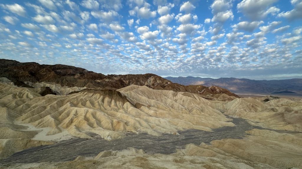 Montagne au ton dégradé sur ciel bleu et nuages parsemés à Zabriskie Point, Death Valley