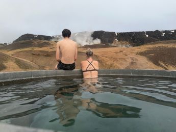 mere et ado de dos, dans une source chaude en plein air en Islande, regardant l'horizon côte à côte