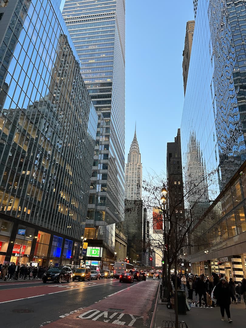 Photo d'une rue de New York, prise entre les buildings, avec le Chrysler building en fond