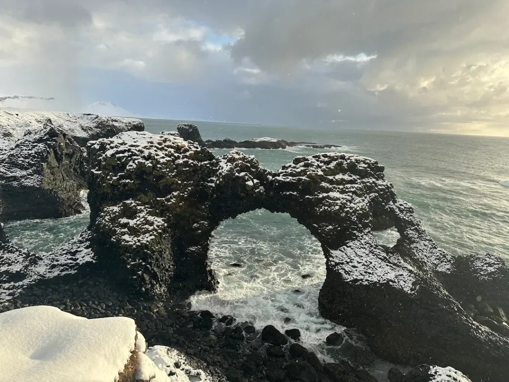 Arche d'Arnastapi recouverte de neige au lever du soleil dans la péninsule de Snæfellsnes en Islande en hiver