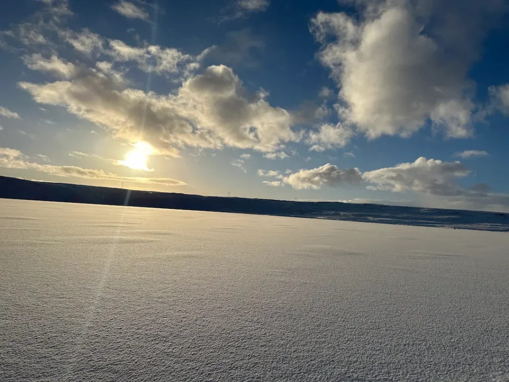 Paysage d'un lac enneigé immaculé au lerer du soleil, à Mosfellsbær, Islande