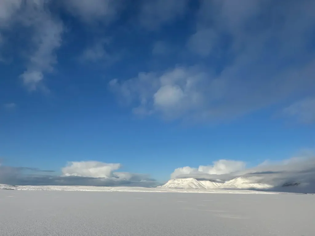 Paysage d'un lac enneigé immaculé sur fond de ciel bleu, à Mosfellsbær, Islande