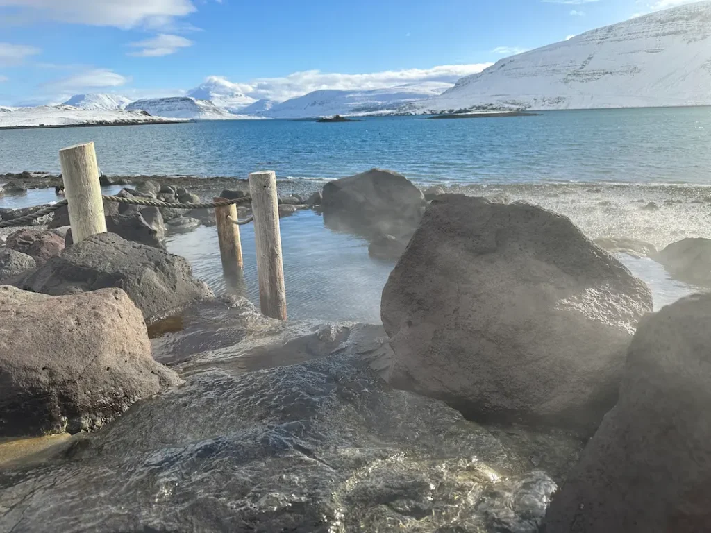 Vue sur le fjord et les montagnes enneigées depuis le bassin de Hvammsvík Hot Springs, Islande