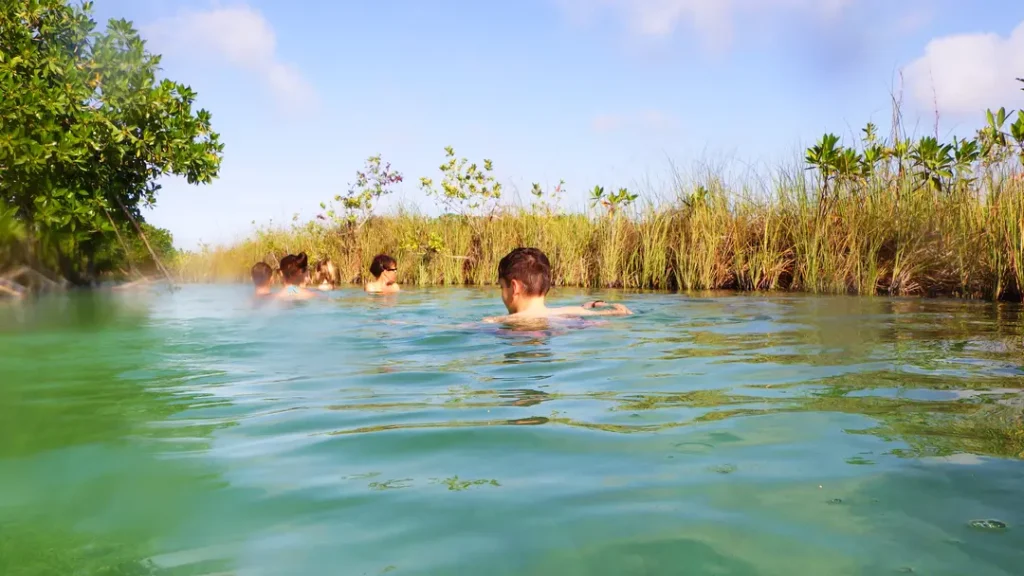 Adolescent et sa maman se baignant dans les canaux dans la réserve de Sian Ka’an à Tulum au Mexique