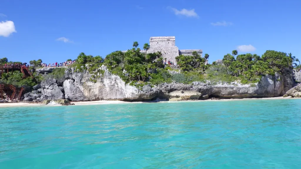 Vue depuis la mer du site archéologique de Tulum visité par une mère et son ado, à Tulum au Mexique