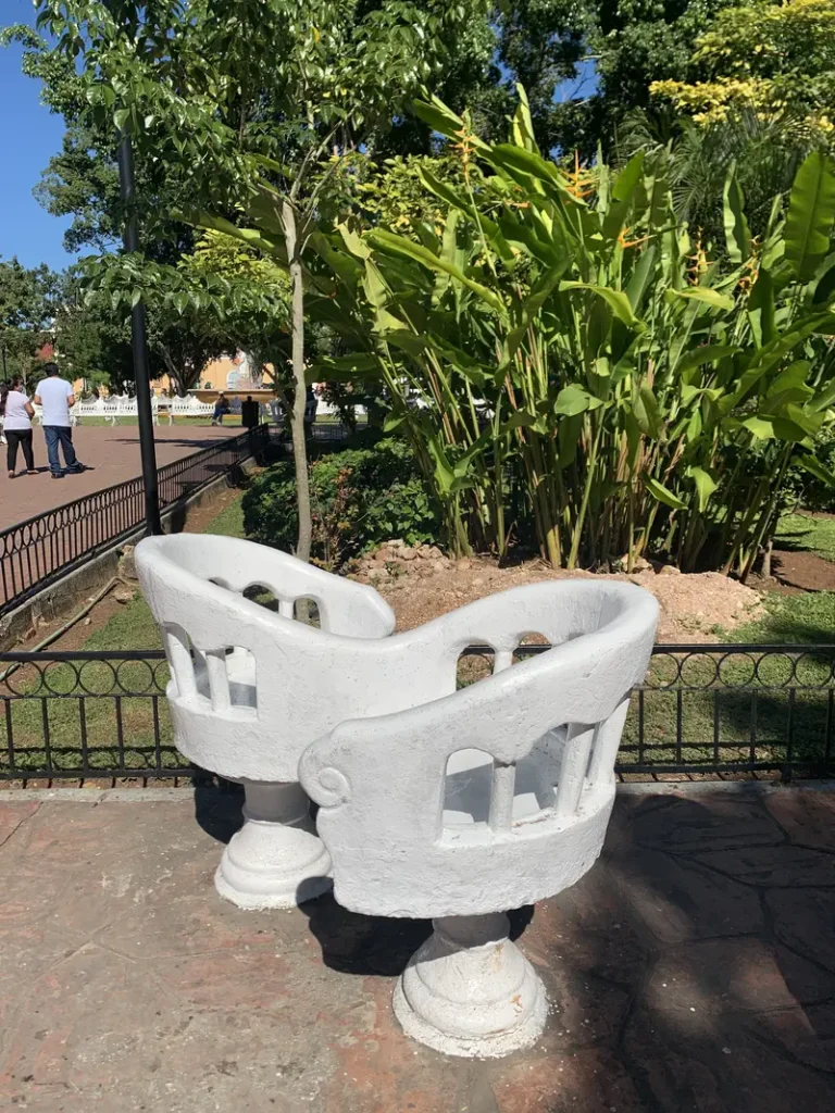 Chaises qui se font face, sur la place El Parque visitée par une mère et son ado à Valladolid au Mexique