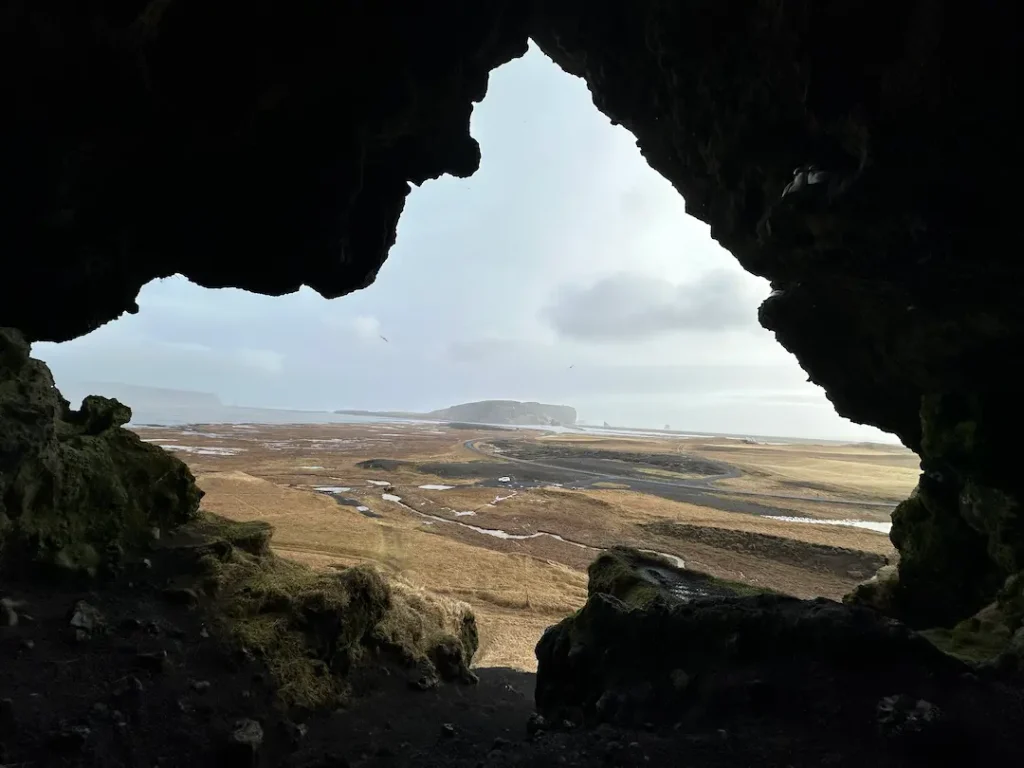 Photo prise depuis l'intérieur de la grotte de Loftsalahellir, avec vue sur la plage de Reynisfjara et la péninsule de Dyrholaey près de Vik en Islande
