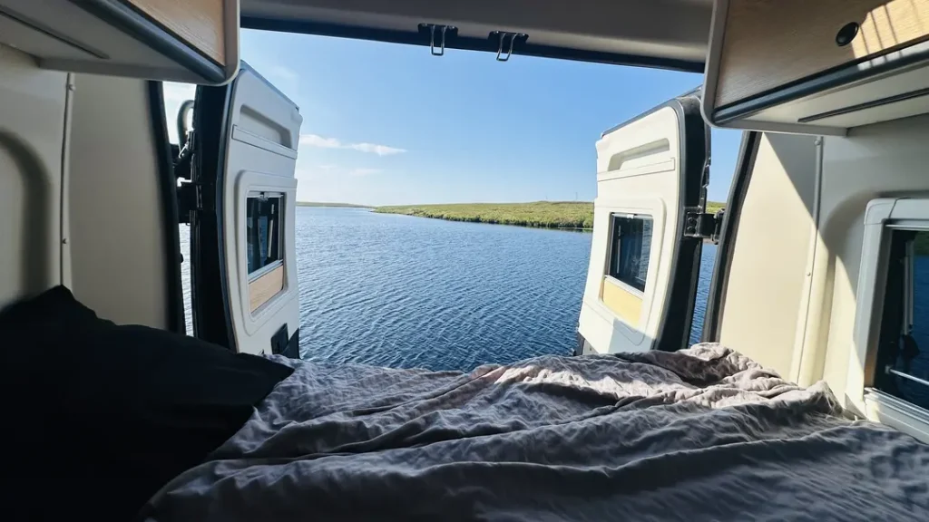 Porte arrière ouverte d'un van aménagé avec vue sur un Loch, Ecosse, royaume Uni